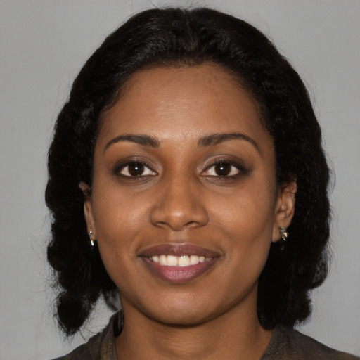 Joyful black young-adult female with medium  black hair and brown eyes
