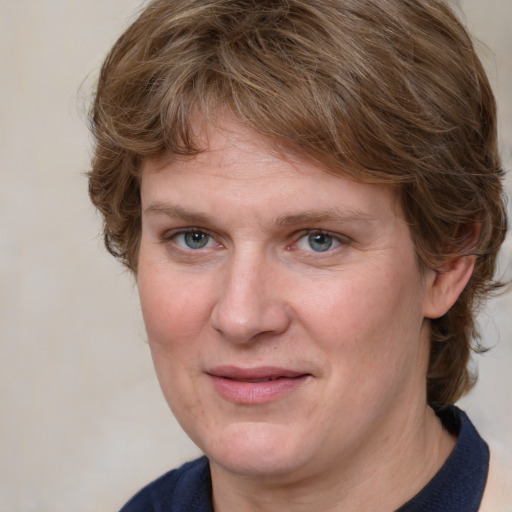 Joyful white adult female with medium  brown hair and blue eyes