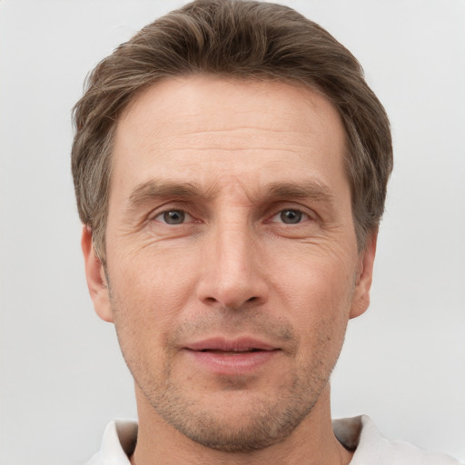 Joyful white adult male with short  brown hair and grey eyes