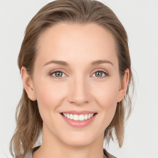 Joyful white young-adult female with medium  brown hair and grey eyes