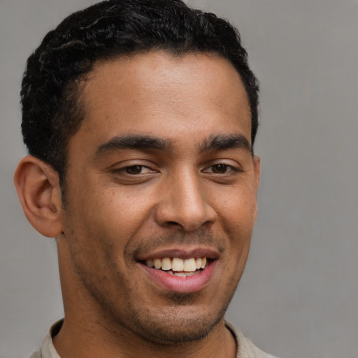 Joyful latino young-adult male with short  brown hair and brown eyes