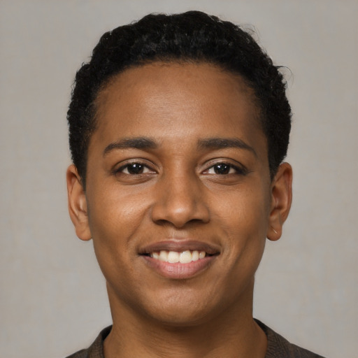 Joyful black young-adult female with short  black hair and brown eyes
