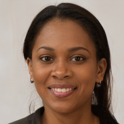 Joyful black young-adult female with long  brown hair and brown eyes