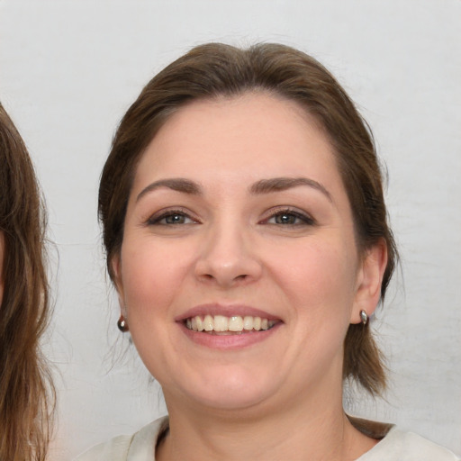 Joyful white young-adult female with medium  brown hair and brown eyes