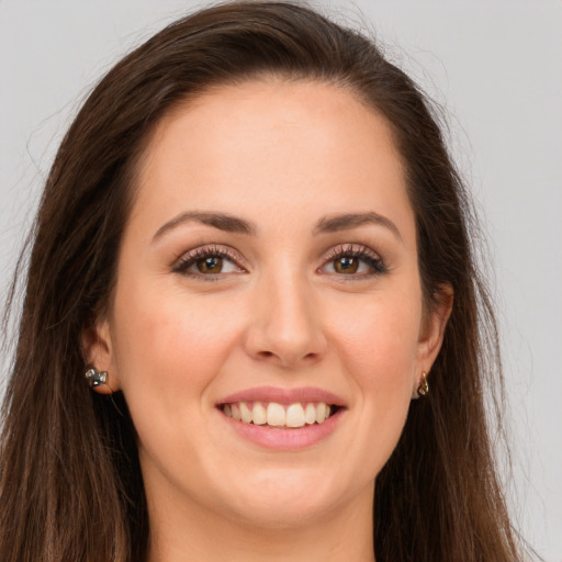 Joyful white young-adult female with long  brown hair and brown eyes