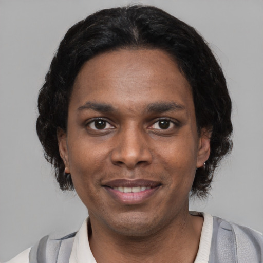 Joyful black young-adult male with short  black hair and brown eyes