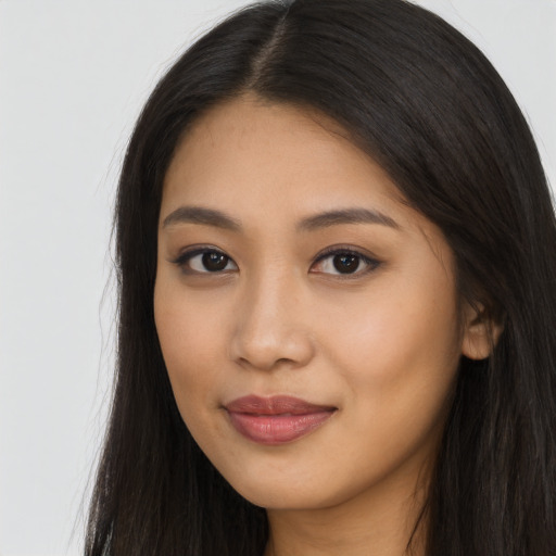 Joyful asian young-adult female with long  brown hair and brown eyes