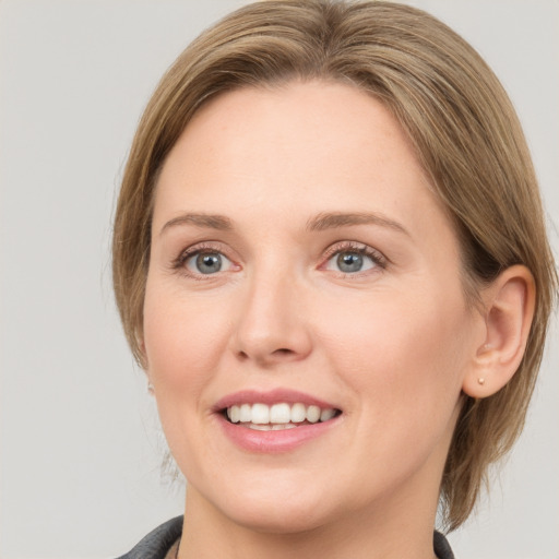 Joyful white young-adult female with medium  brown hair and blue eyes