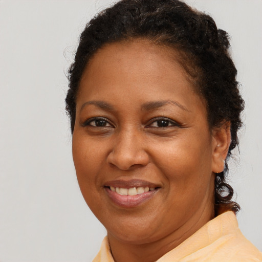 Joyful black adult female with short  brown hair and brown eyes