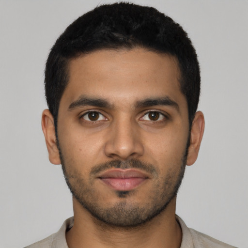 Joyful latino young-adult male with short  black hair and brown eyes