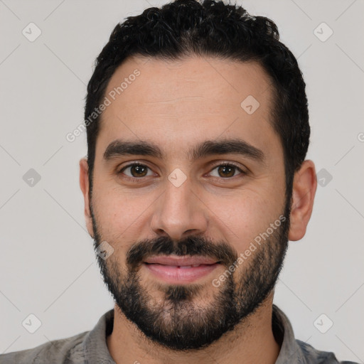 Joyful white young-adult male with short  black hair and brown eyes