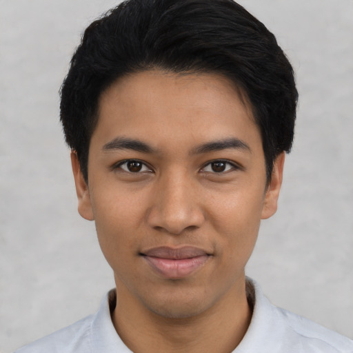 Joyful latino young-adult male with short  black hair and brown eyes