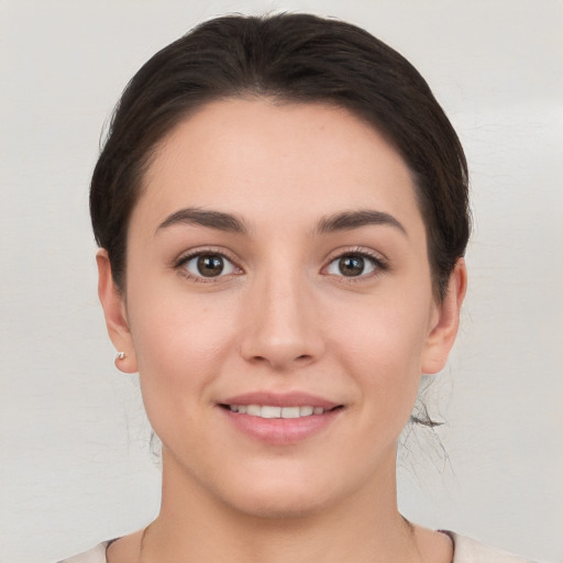 Joyful white young-adult female with short  brown hair and brown eyes