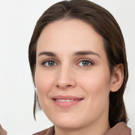 Joyful white young-adult female with medium  brown hair and grey eyes