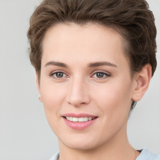 Joyful white young-adult female with short  brown hair and grey eyes