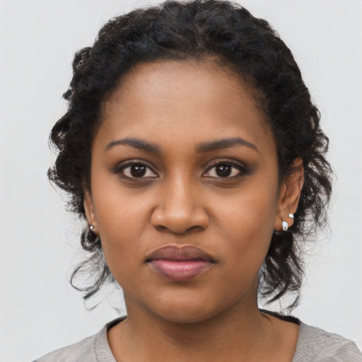 Joyful black young-adult female with medium  black hair and brown eyes