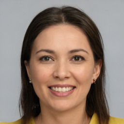 Joyful white young-adult female with long  brown hair and brown eyes