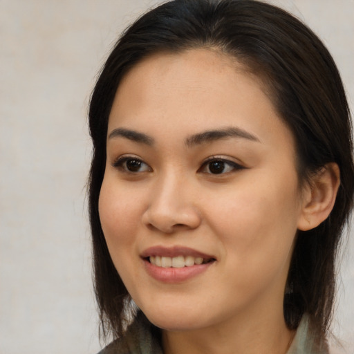 Joyful asian young-adult female with long  brown hair and brown eyes