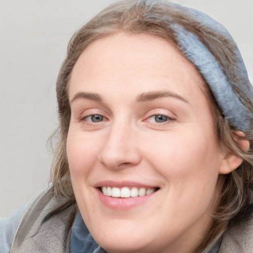 Joyful white young-adult female with medium  brown hair and blue eyes