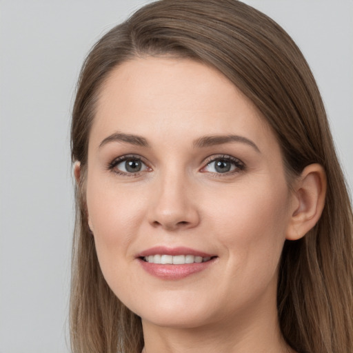 Joyful white young-adult female with long  brown hair and grey eyes