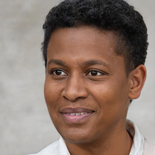 Joyful black young-adult male with short  brown hair and brown eyes