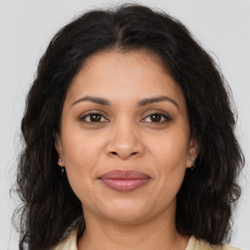 Joyful latino adult female with long  brown hair and brown eyes