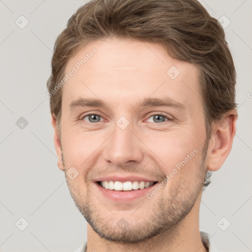 Joyful white young-adult male with short  brown hair and grey eyes