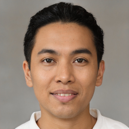 Joyful latino young-adult male with short  black hair and brown eyes