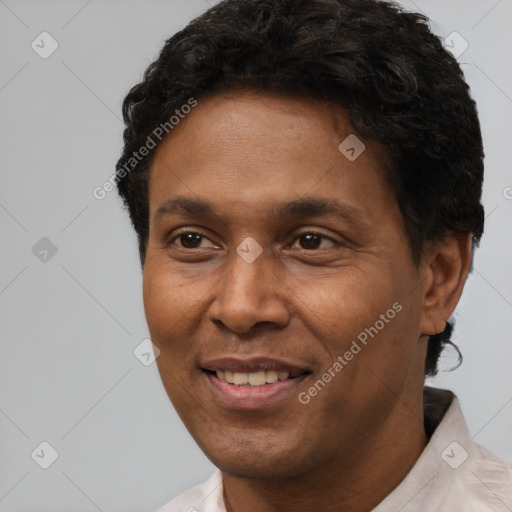 Joyful black adult male with short  black hair and brown eyes