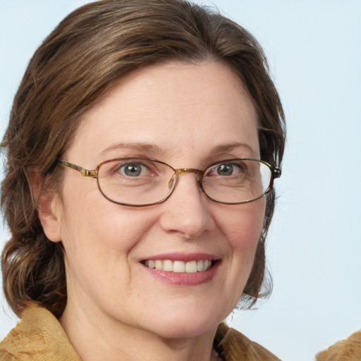 Joyful white adult female with medium  brown hair and blue eyes