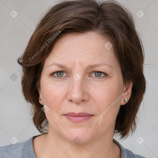 Joyful white adult female with medium  brown hair and grey eyes