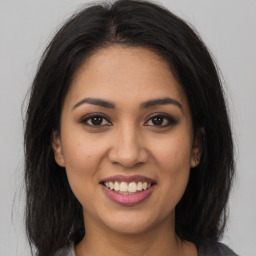 Joyful latino young-adult female with long  brown hair and brown eyes