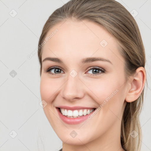 Joyful white young-adult female with long  brown hair and grey eyes