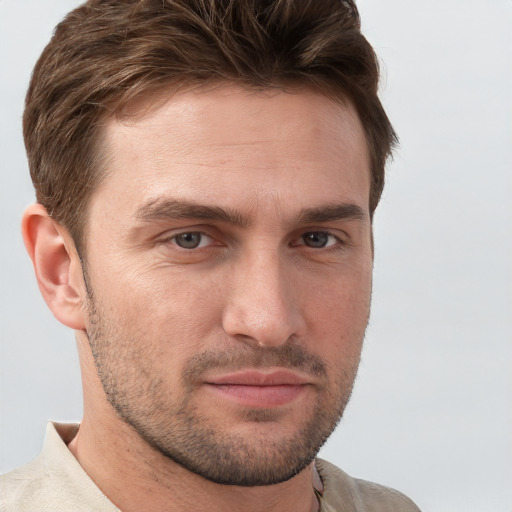 Joyful white young-adult male with short  brown hair and grey eyes