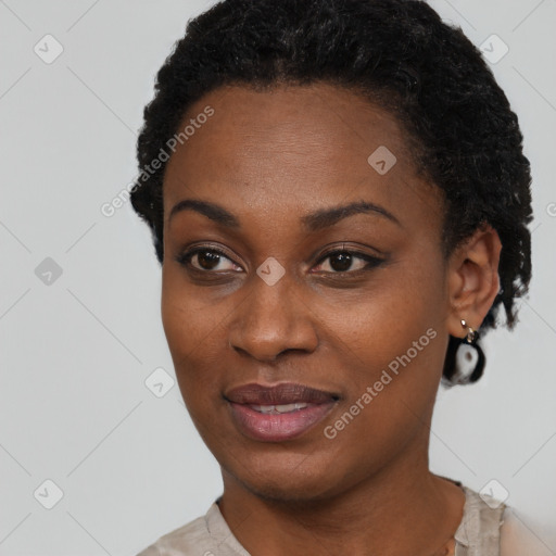 Joyful black young-adult female with short  black hair and brown eyes