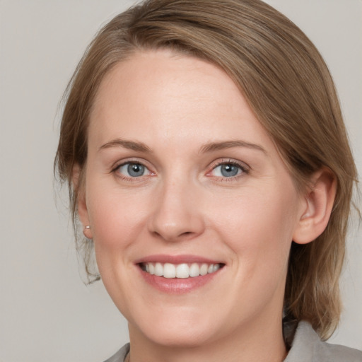 Joyful white adult female with medium  brown hair and blue eyes