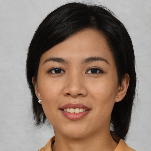 Joyful asian young-adult female with medium  black hair and brown eyes