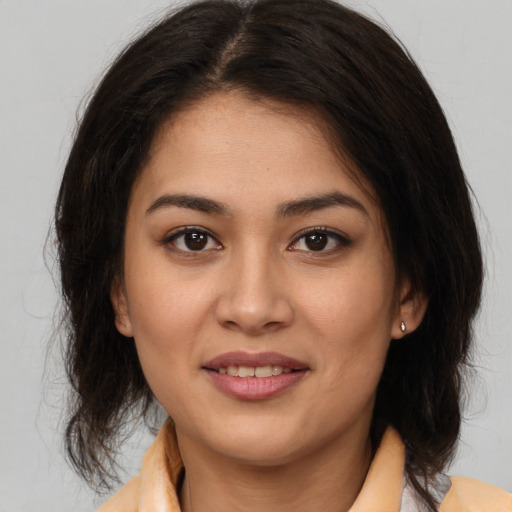 Joyful latino young-adult female with medium  brown hair and brown eyes