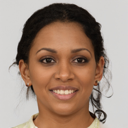 Joyful black young-adult female with medium  brown hair and brown eyes