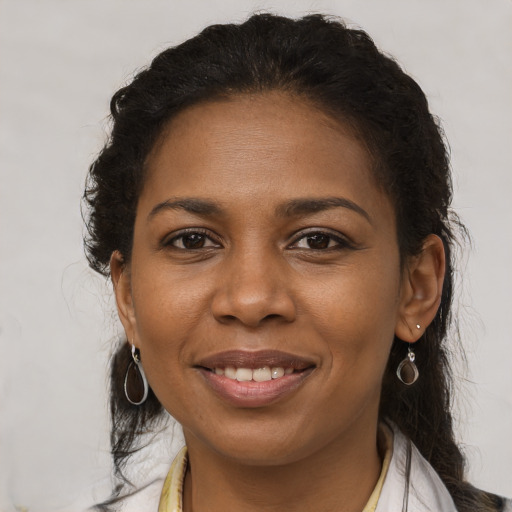 Joyful black adult female with medium  brown hair and brown eyes