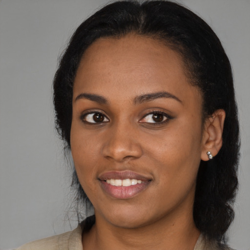 Joyful black young-adult female with long  black hair and brown eyes