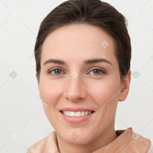 Joyful white young-adult female with short  brown hair and grey eyes