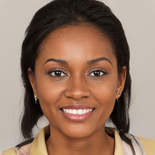 Joyful black young-adult female with long  brown hair and brown eyes