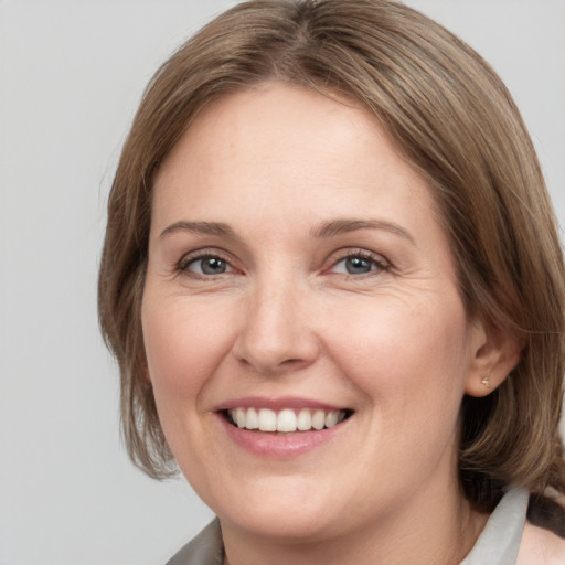 Joyful white adult female with medium  brown hair and grey eyes