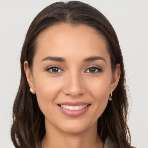 Joyful white young-adult female with long  brown hair and brown eyes