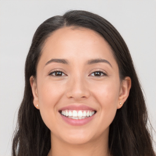 Joyful white young-adult female with long  brown hair and brown eyes