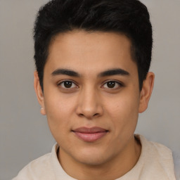 Joyful latino young-adult male with short  black hair and brown eyes