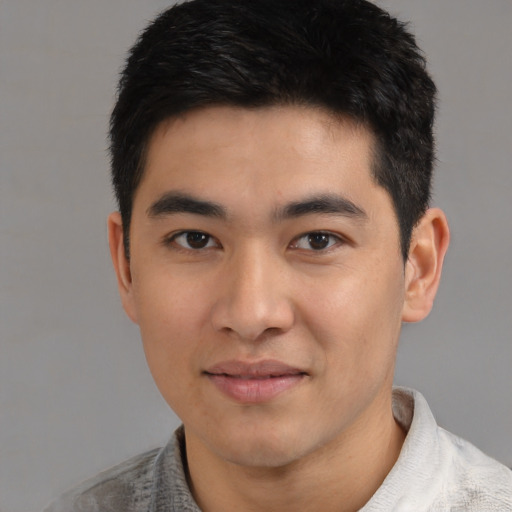 Joyful asian young-adult male with short  black hair and brown eyes