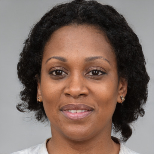 Joyful black adult female with medium  brown hair and brown eyes