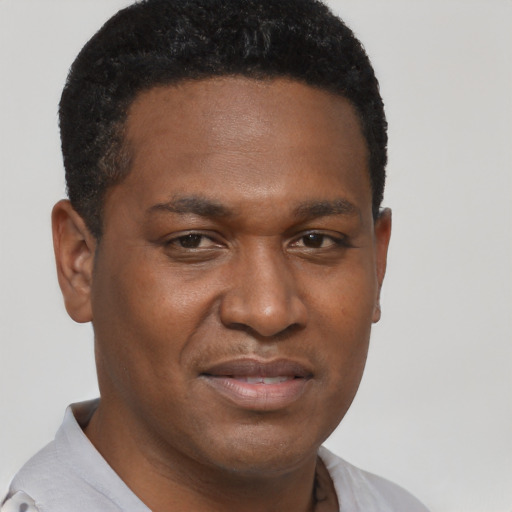 Joyful black young-adult male with short  black hair and brown eyes